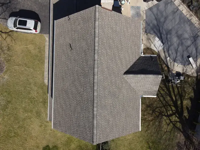 A detached shed with a green standing seam metal roof. 
