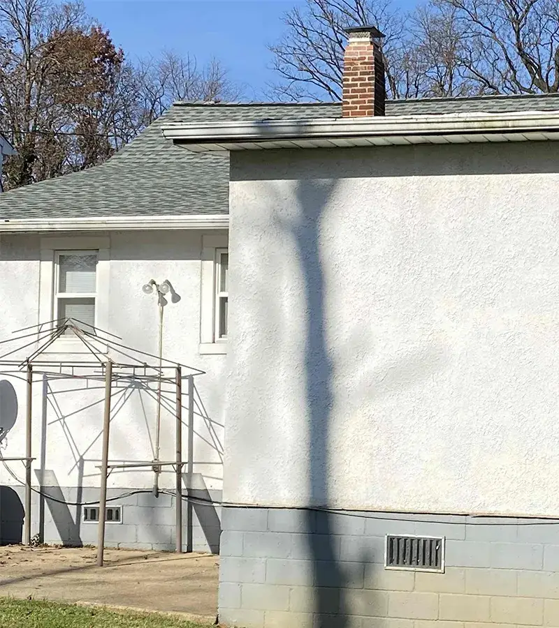 A detached shed with a green standing seam metal roof. 