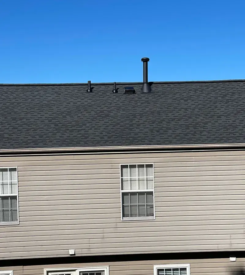 A detached shed with a green standing seam metal roof. 