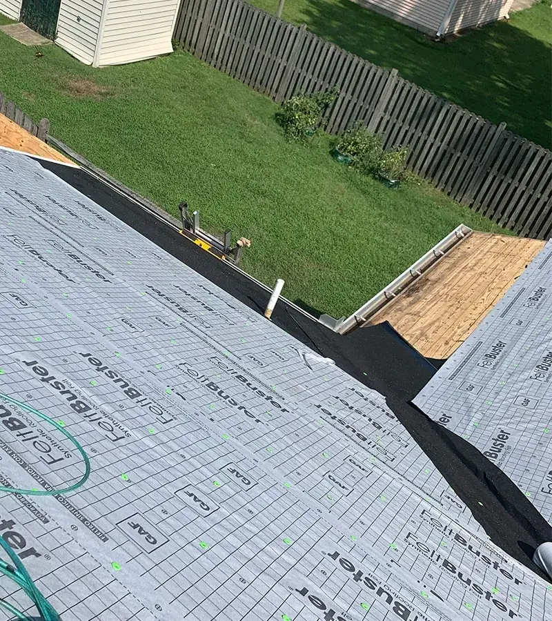 A detached shed with a green standing seam metal roof. 