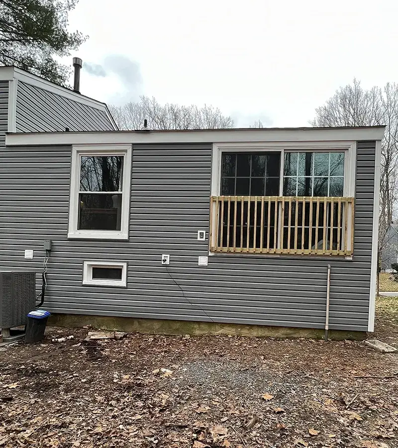 A detached shed with a green standing seam metal roof. 