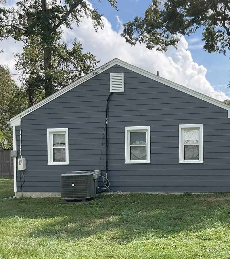 A detached shed with a green standing seam metal roof. 