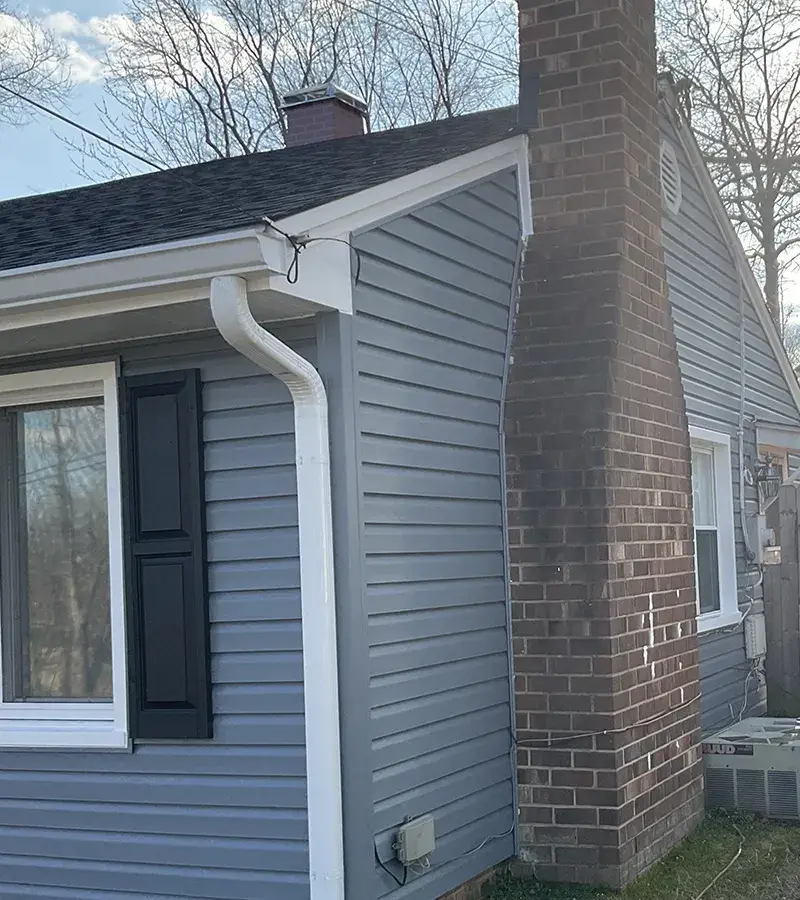 A detached shed with a green standing seam metal roof. 