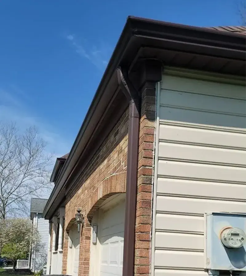 A detached shed with a green standing seam metal roof.