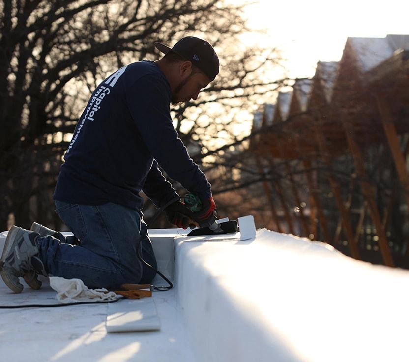 Capitol Improvements employee working on a TPO flat roof in Washington, DC.