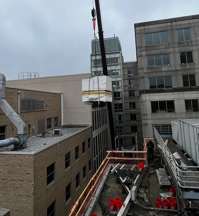 Crane delivery of materials on a commercial flat roof installation in Washington, DC.