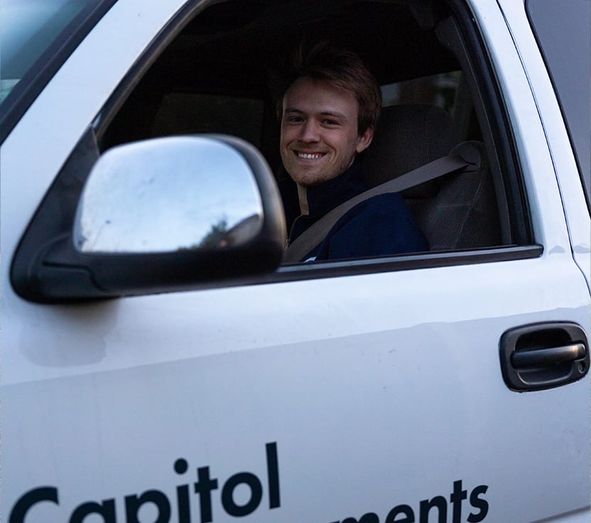 Capitol Improvements employee smiling and greeting a client. 