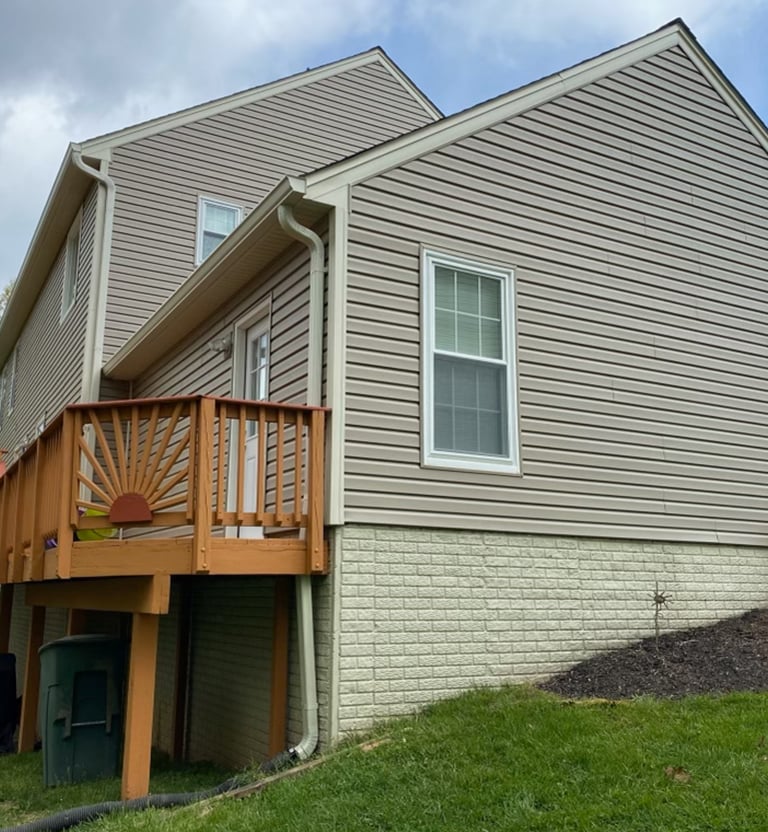 Neutral tan siding with white trim and white corners. 