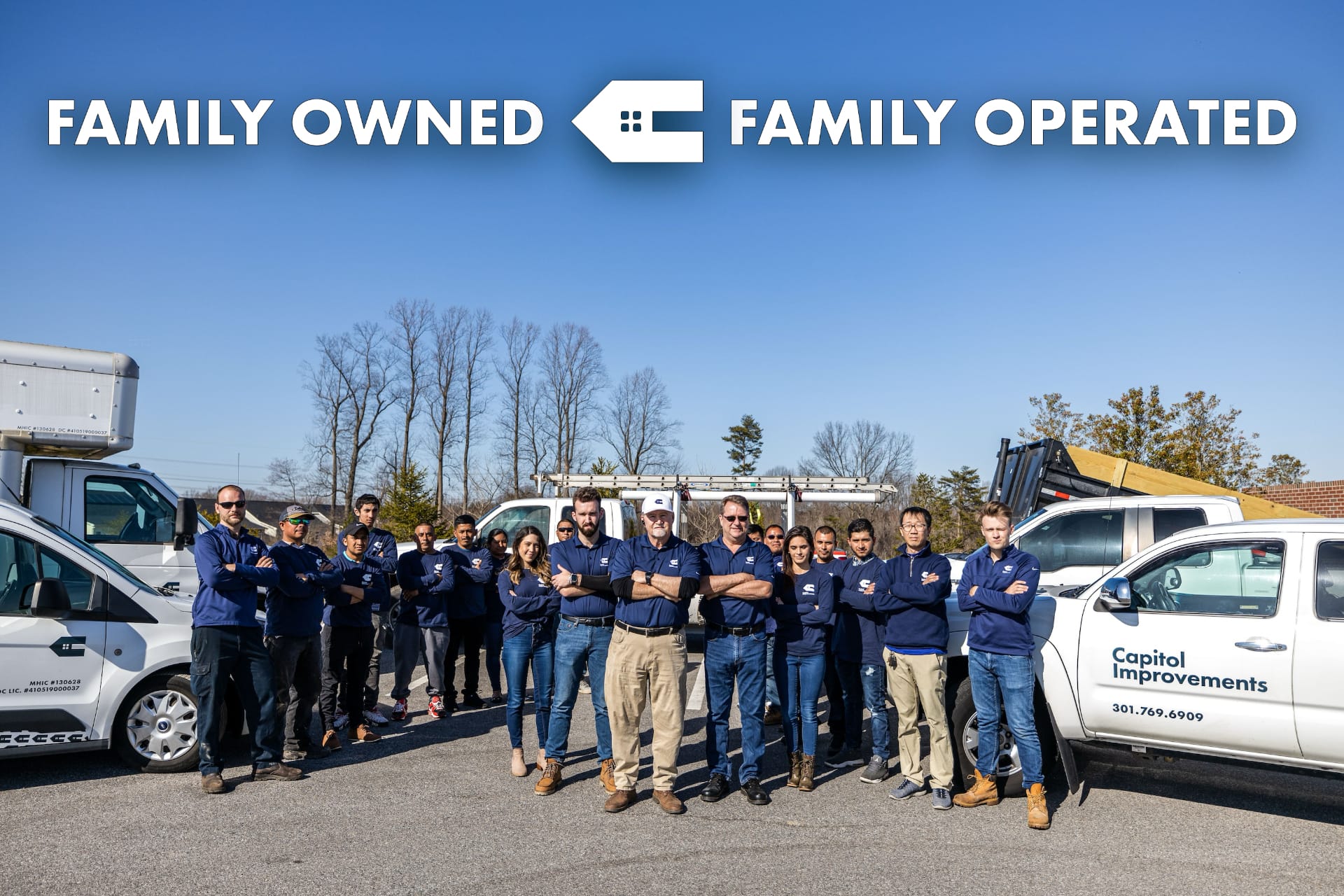 The Capitol Improvements family-owned team standing with company trucks at Bowie, MD headquarters